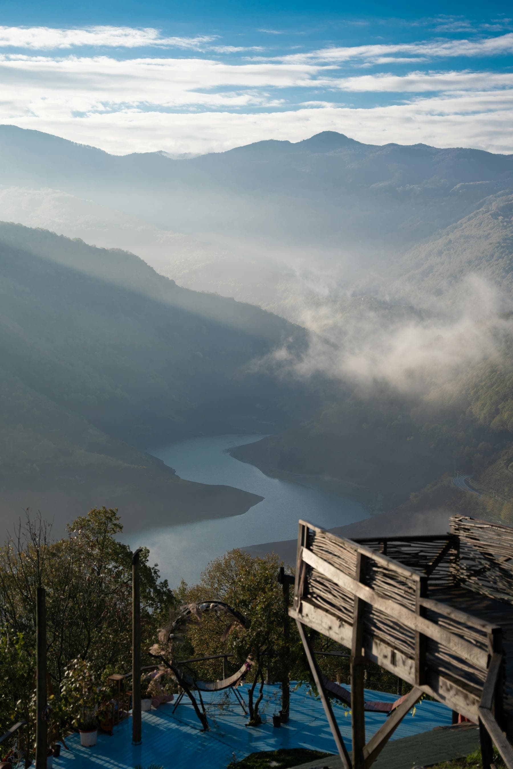 Mountain valley with mist and a winding river.