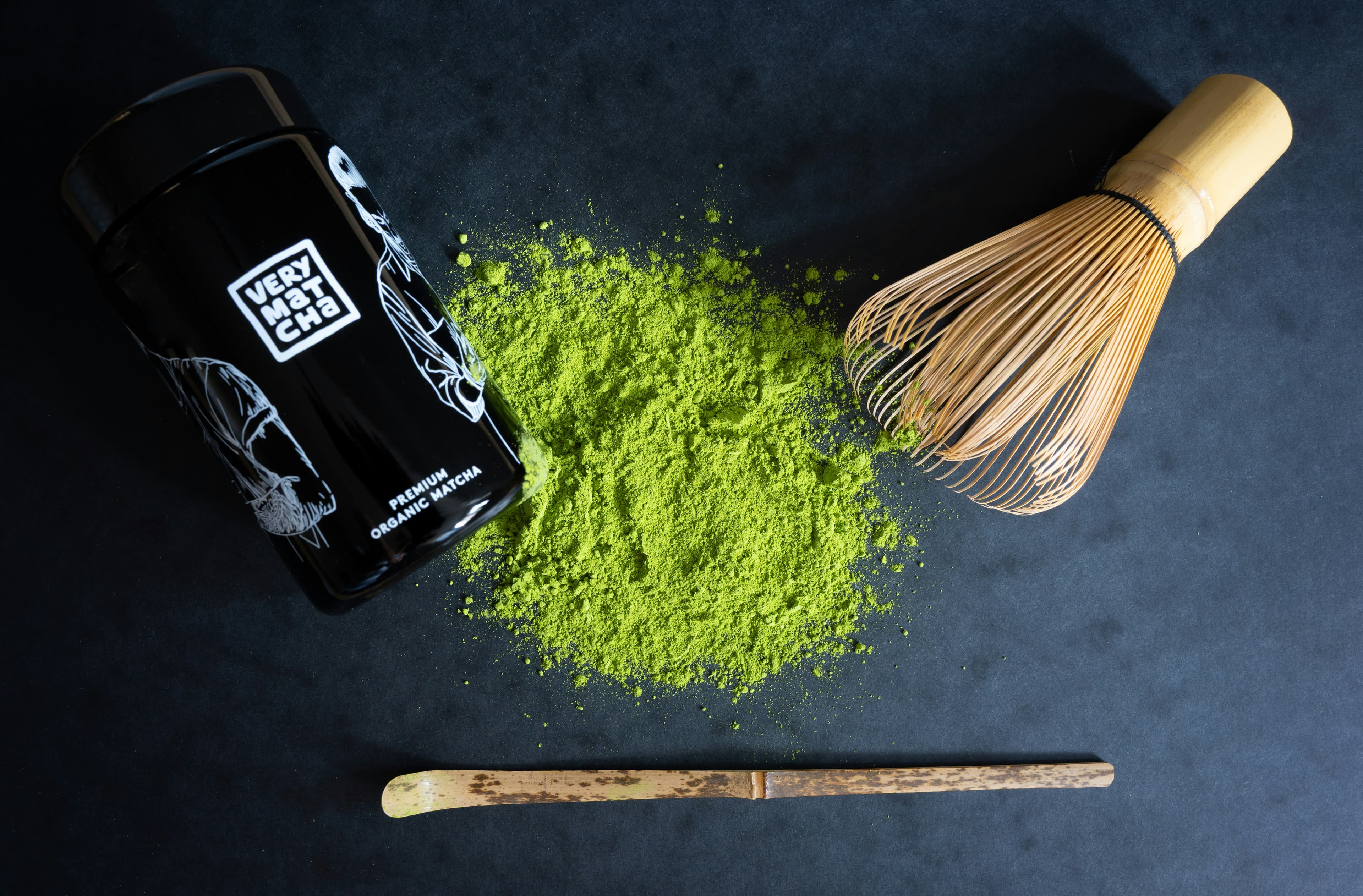 Matcha tools and product styling shot on a textured surface.